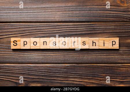 Sponsoring Wort auf Holz Block geschrieben. Sponsoring text auf Tisch, Konzept. Stockfoto