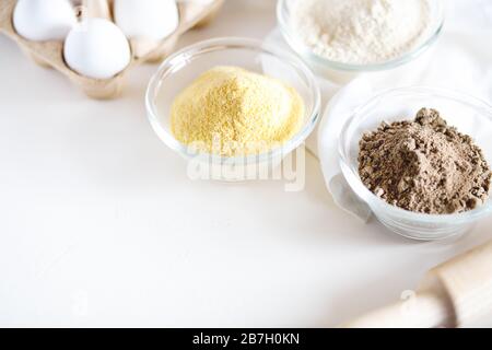 Verschiedene glutenfreie Mehlkorn, Sesam, Hafer, Kokosnuss in der Schüssel auf weißem Hintergrund.Alternative zu Weizenmehl für Paläo-Diät.gesunde Ernährung,nährende Lebensmittel Co Stockfoto