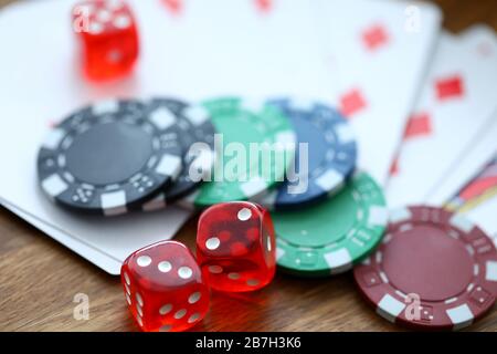 Rote Würfel, die mit Casino-Chips als Glückssymbol liegen Stockfoto