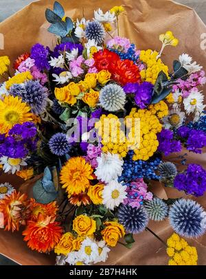 Leuchtend getrocknete Blumenarrangement in violetten und gelben Farben Stockfoto
