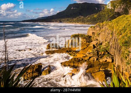 Abstürzende Wellen am Strand in Punakaiki, Westküste, Neuseeland Stockfoto