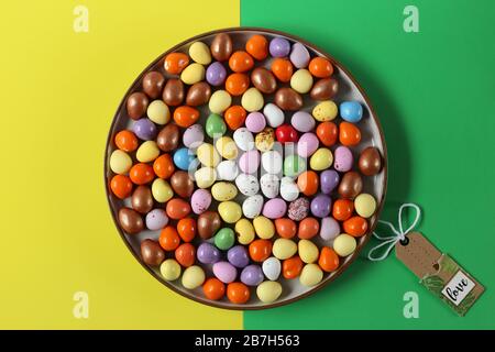Ostern mehrfarbige Eier auf runder Platte, Oster-Gelb-Grün-Hintergrund flach gelegt Stockfoto