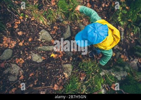 Kleiner Junge Wandern in den Bergen, Familienabenteuer, Draufsicht. Kleines Kind, das in einem felsigen grünen Wald spazieren geht. Stockfoto