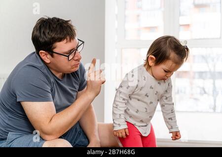 Vater bestraft seine Tochter wegen ihres schlechten Verhaltens. Strenges Elternkonzept Stockfoto