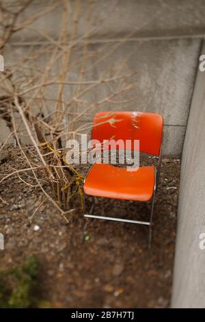 Orangefarbener Stuhl außerhalb von Dead Tree Stockfoto