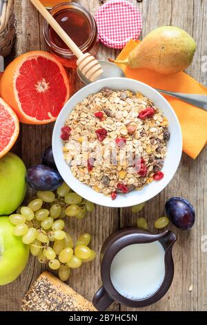 Gesunde Frühstückswohnung lag. Eine Schüssel mit frischen Früchten und Haferbrei auf Holzhintergrund. Vertikales Porträt von Lebensmitteln für einen gesunden Lebensstil. Stockfoto