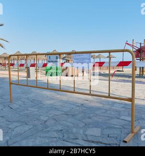 Ein örtliches Polizeischild warnt Urlauber vor einer Strandschließung aufgrund von sozialen Distanzierungsmaßnahmen des Coronavirus, Nerja, Málaga, Spanien Stockfoto