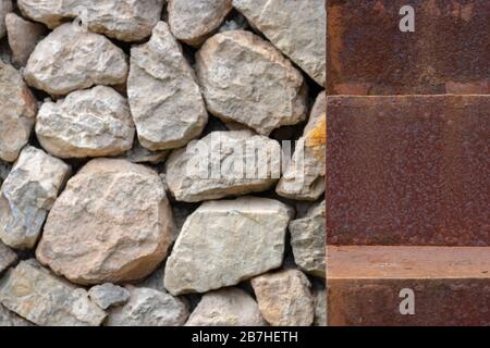 Nahaufnahme eines rostigen Schrittes einer Treppe neben einer Steinmauer Stockfoto