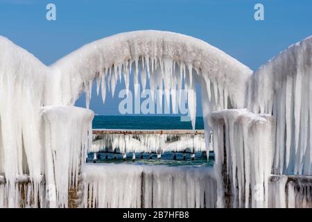 Eiszapfen über den Bögen des verlassenen Schwimmbades am Meer Stockfoto