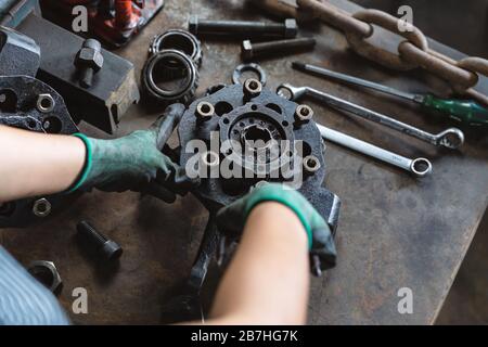 Industriearbeiter, Reparatur von Autoteilen in der Kfz-Werkstatt - Maschinenbau-Inspektion und Justierung von Fahrzeugteilen - Fertigungswerk, Studenten-Lehrling und Facharbeiterkonzept Stockfoto