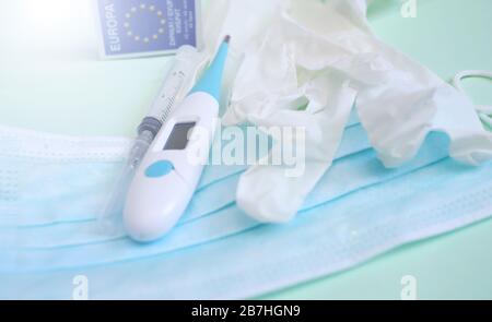 Konzept zur Vorbeugung von Coronavirus. Schutzmaske, Handschuhe, Thermometer, Spritze und Europa-Schild. Covid-19 Quarantäne. Stockfoto