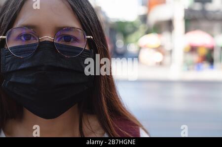 Verschiedene asiatische Mädchen, die eine Gesichtsmaske tragen, um die Verschmutzung der Stadt und virale Atemwegserkrankungen zu schützen - junge, tausendjährige Frau, die bei einer globalen Virus-Pandemie einen operativen Einwegschutz verwendet Stockfoto