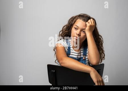 Portrait Mädchen sitzt mit gestreifter Weste isoliert. Kopierraum Stockfoto