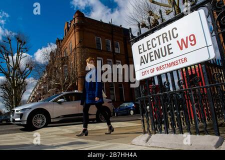 Babs Watson passiert einen Jaguar i-Pace auf der Sutherland Avenue, London, die als Electric Avenue, W9, geprägt wurde, um zu markieren, dass alle Laternenpfade auf der Straße vollständig zu SIEMENS und Ubitricity Electric Fahrzeugladestationen umgebaut wurden. Stockfoto