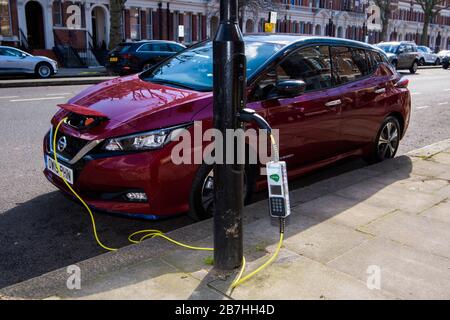 VERÖFFENTLICHT AUF 0001 DIENSTAG, 17. MÄRZ REDAKTIONELLE VERWENDUNG NUR ein elektrischer Nissan Leaf wird an der Sutherland Avenue, London, aufgeladen, die als Electric Avenue, W9, geprägt wurde, um zu kennzeichnen, dass alle Leuchter auf der Straße vollständig auf SIEMENS und Ubitricity Electric Fahrzeugladestellen umgestellt wurden. Stockfoto