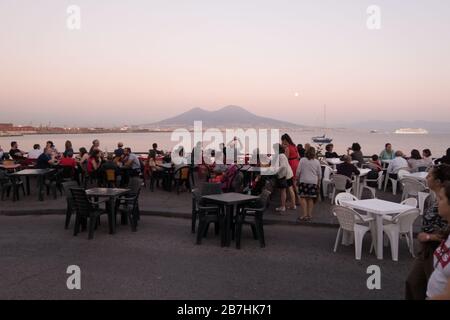 Die Leute sitzen in einem Café im Freien in der Bucht von Neapel mit Blick auf den Vesuvio Stockfoto