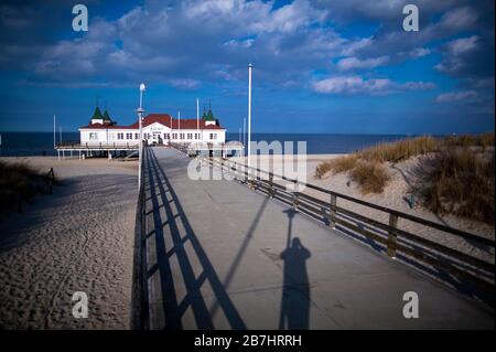 Ahlbeck, Deutschland. März 2020. Nur wenige Urlauber sind am Pier. Die Zufahrten zu baltischen Inseln wie Usedom, Rügen oder Poel sollen wegen des Coronavirus streng kontrolliert werden; Urlauber sollen die Touristenzentren verlassen. Der Grund für die Blockade ist, dass die Gesundheitssysteme der Inseln nicht für eine größere Anzahl von Menschen vorbereitet sind, die mit dem neuen Coronavirus infiziert sind. Credit: Jens Büttner / dpa-Zentralbild / dpa / Alamy Live News Credit: Dpa Picture Alliance / Alamy Live News Credit: Dpa Picture Alliance / Alamy Live News Stockfoto