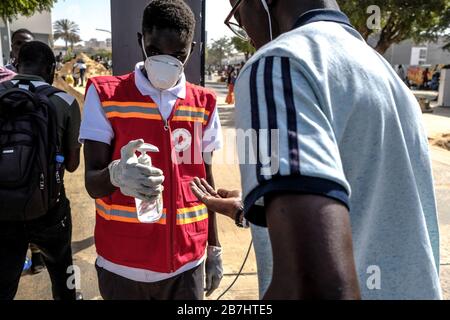 Dakar, Senegal. März 2020. (200316) -- DAKAR, 16. März 2020 (Xinhua) -- EIN Rotkreuz-Freiwilliger gibt Studenten an der Cheikh Anta Diop Universität Dakar in Dakar, Senegal, am 16. März 2020 Handdesinfektionsmittel aus. Der Senegal, das am zweitstärksten betroffene Land in Afrika südlich der Sahara, hat 26 Fälle von COVID-19 gemeldet, darunter zwei Fälle, die für geheilt und aus dem Krankenhaus entlassen erklärt werden. Der senegalesische Präsident Macky Sall kündigte am 14. März an, alle öffentlichen Veranstaltungen auf senegalesischem Gebiet für einen Zeitraum von 30 Tagen als Maßnahme zur Bekämpfung von COVID-19 im westafrikanischen Land zu verbieten. Gutschrift: Xinhua/Alamy Live Ne Stockfoto