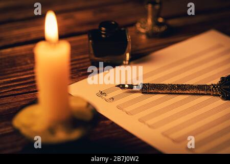 Vintage-Manuskript - Schreiben von Musiknoten bei Kerzenlicht Stockfoto