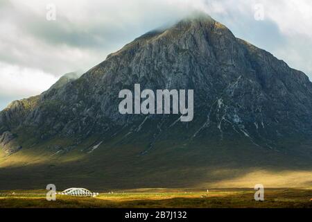 Dramatische Ausblicke auf die schroffe Wand von Stob Dearg auf Buachaille Etive Mor in Sonnenschein und Schatten, Glen Coe, Rannoch Moor, Schottland, Großbritannien Stockfoto