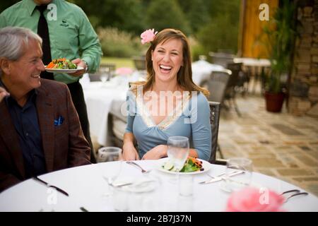 Frau mittleren Erwachsenen, die beim Abendessen serviert wird, während sie mit ihrem erwachsenen Vater in einem Restaurant sitzt. Stockfoto