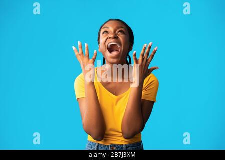 Emotionale Afrikanerin Schreit Stehend Über Blauem Hintergrund, Studio Erschossen Stockfoto