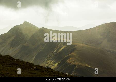 Von den Hängen des Ben Nevis heben die Wellen des Sonnenlichts die zerklüfteten Seiten des Glen Nevis, Fort William, Schottland, mit Mullach nan Coirean in der Ferne hervor Stockfoto