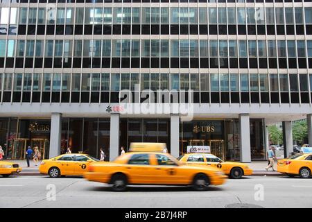 NEW YORK, USA - 4. JULI 2013: Gelbe Kabine fährt von der UBS-Bank an der Avenue of the Americas (6th Avenue), New York City. Stockfoto