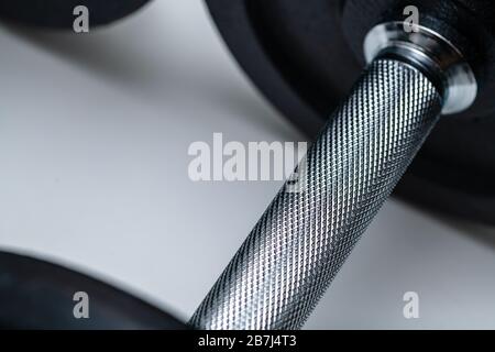 Nahaufnahme des verstellbaren Hantelgriffs mit aufgesetzten Gewichten auf weißem Hintergrund. Konzept von Training, Fitness und Bewegung für ein gesundes Leben. Stockfoto