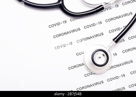 Stethoskop mit Coronavirus- und COVID-19-Musterwörtern Stockfoto