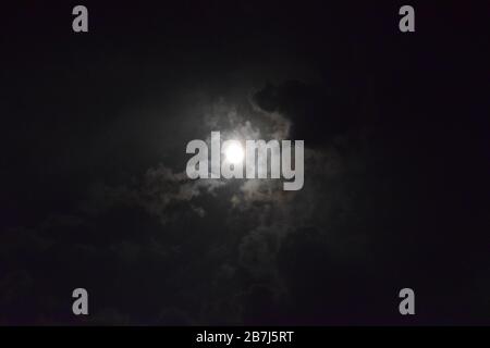 Wunderschöner Blick auf den Himmel mit Mond und Wolken, die ihn bedecken Stockfoto