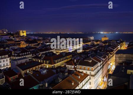 Blick auf die beleuchtete SE-Kathedrale und Arco da Rua Augusta, Gebäude im Baixa-Viertel und den Fluss Tejo in Lissabon, Portugal, von oben in der Abenddämmerung. Stockfoto