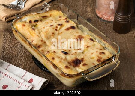 Eine Backform glutenfreier Cannelloni auf einem Holztisch. Stockfoto