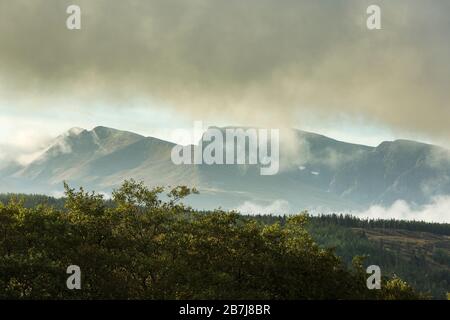 Low Cloud and Drifting Mists über Carn Mor Dearg und der Nordwand von Ben Nevis, mit Schneemücken, vom Great Glen Way, Schottland, Großbritannien aus gesehen Stockfoto