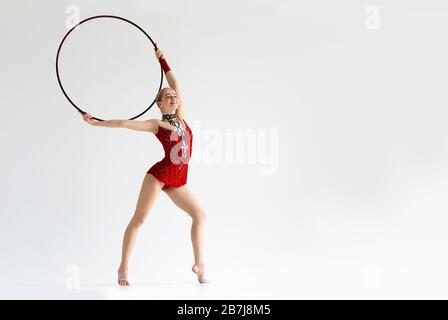 Weibliche Turnerin, die mit Hula Hoop auf weißem Hintergrund auftritt, Platz für Text Stockfoto