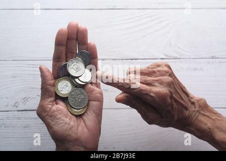 Ältere Frauen zählen Münzen und sparen Geld Stockfoto