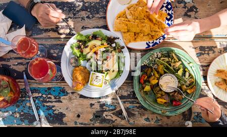 Blick auf vegetarisches Mittagessen im Freien auf einem rustikalen Esstisch Stockfoto