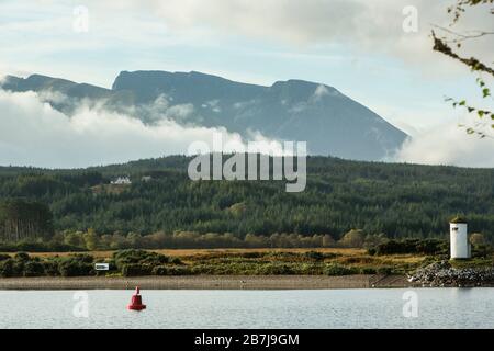 Die Nordwand des Ben Nevis, des höchsten Bergs der Briten, über Loch Lochy vom Great Glen Way mit Gairlochy Pepperpot Lighthouse aus gesehen. Stockfoto