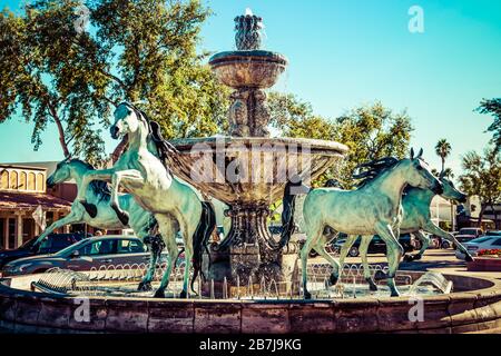 Die geliebten arabischen Pferdestatuen aus Bronze mit Springbrunnen, entlang des "Kunstwerks der Linie"-Bereichs der Altstadt von Scottsdale, AZ, USA Stockfoto