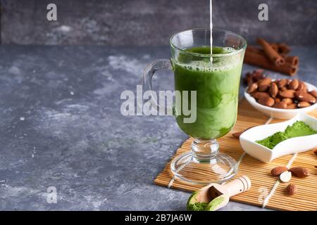 Grüner Tee Matcha mit Creme in Glas auf grauem Steinhintergrund Kopierraum Stockfoto
