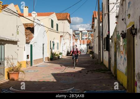 Man radelt auf der malerischen Rua 15, Costa de Caparica, Almada, Portugal Stockfoto