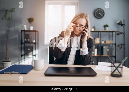 Geschäftsfrau spricht nach dem Arbeitstag über Smartphone Stockfoto