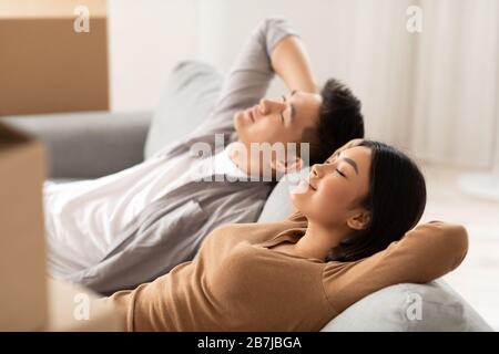 Asiatisches Paar liegt auf neuem Sofa und schläft Stockfoto