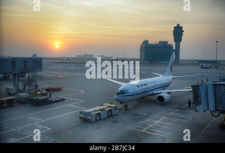 HONGKONG, 22. November 2009: Air China Airlines besteuern internationalen Flughafen Hongkong bei dramatischem Sonnenuntergang. Stockfoto