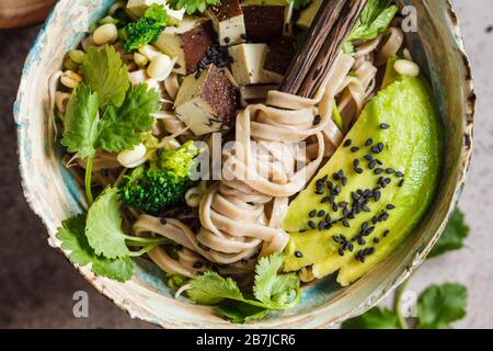 Buchweizen nudeln Soba mit Tofu, Brokkoli, Avocado, Sämlinge und Koriander. Gesunde vegane Ernährung Konzept. Stockfoto