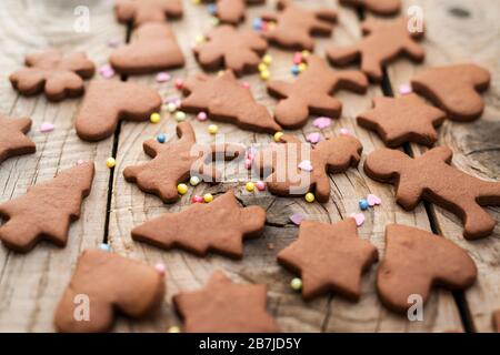 Weihnachts-Lebkuchen-Plätzchen mit verschiedenen Formen über einem alten Holztisch Stockfoto