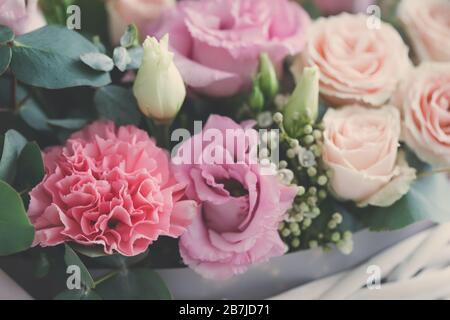 Pastellfarbene Blumen in weißem Korb isoliert, floristische Hochzeit präsentieren Hintergrund, 8. März, Frauen, Muttertag Postkartenkonzept Stockfoto