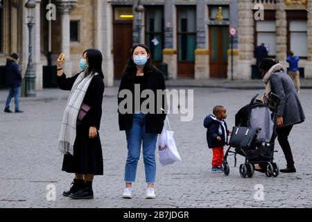 Brüssel, Belgien. März 2020. Menschen, die nach einem Ausbruch des Coronavirus schützende Gesichtsmasken tragen, machen sich im historischen Zentrum Brüssels auf den Weg. Credit: ALEXANDROS MICHAILIDIS/Alamy Live News Stockfoto