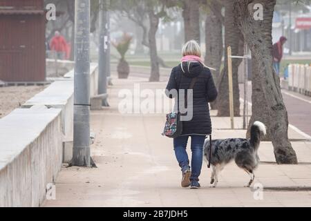 Cala Millor, Spanien. März 2020. Eine Frau geht mit ihrem Hund. Während der Ausgangssperre in Spanien ist das gehen ausdrücklich erlaubt. Um die sich schnell ausbreitende Coronavirus Epidemie zu bekämpfen, erklärte die spanische Regierung am Samstagabend eine zweiwöchige Ausgangssperre. Credit: Bodo Marks / dpa / Alamy Live News Stockfoto