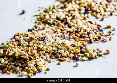 Mischung aus trockenen Bohnen, Erbsen, Linsen und Bohnenmaschen. Rohzutaten für Bohnensuppe im Hintergrund. Stockfoto